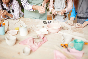High angle closeup of children making handmade ceramics in pottery workshop, copy space