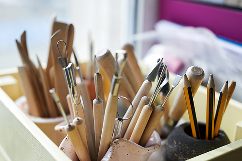 Closeup of crafting tools in pottery workshop, copy space