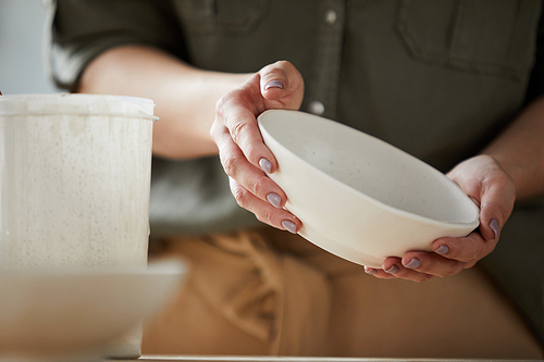 Mid section closeup of female artisan holding beautiful ceramic bowl in hands, copy space