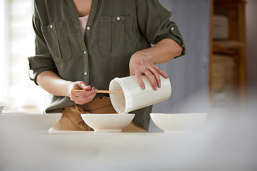 Mid section portrait of contemporary female ceramist working in pottery studio, copy space
