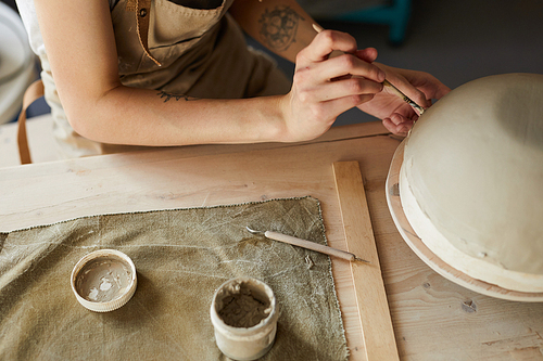High angle close up of unrecognizable female artisan shaping handmade bowl on potters wheel, copy space