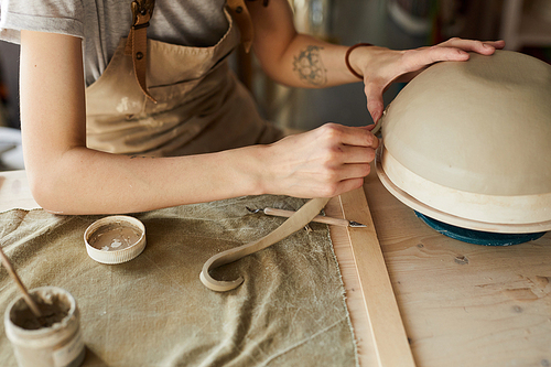 High angle portrait of unrecognizable female artisan shaping bowl on potters wheel, copy space