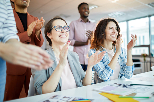 Portrait of multi-ethnic business team clapping happily listening to  presentation in office, copy space