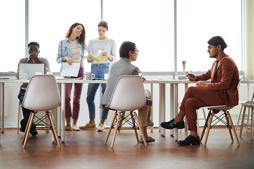 Diverse group of contemporary business people working at table in office, copy space