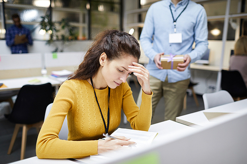 serious upset young woman tired from work sitting at desk in office and rubbing forehead while reading notes in 다이어리