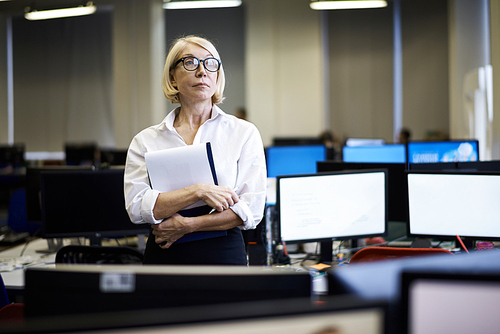 Waist up portrait of pensive senior businesswoman posing in office and looking away, copy space