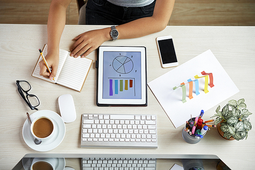 Businesswoman working on annual financial report, view from above