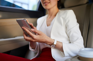 Mid section portrait of businesswoman using smartphone in taxi closeup, copy space