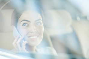 Portrait of smiling businesswoman using smartphone in taxi and looking at window, copy space