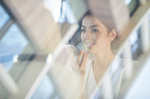 Portrait of young businesswoman speaking by smartphone in taxi on loudspeaker, copy space