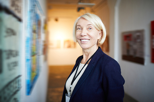 Waist up portrait of smiling mature woman in art gallery  , copy space