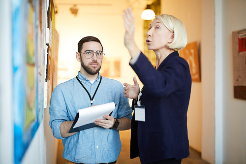 Waist up portrait of two museum workers in exhibition in art gallery, copy space