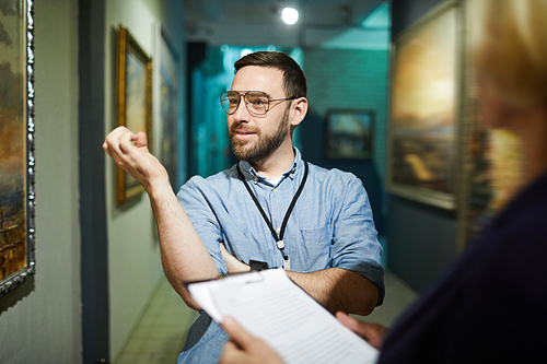 Waist up portrait of two visitors discussing paintings standing in art gallery or museum, copy space