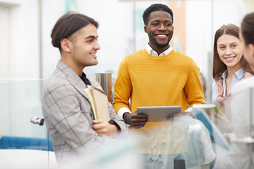 Multi-ethnic group of students chatting during break in college