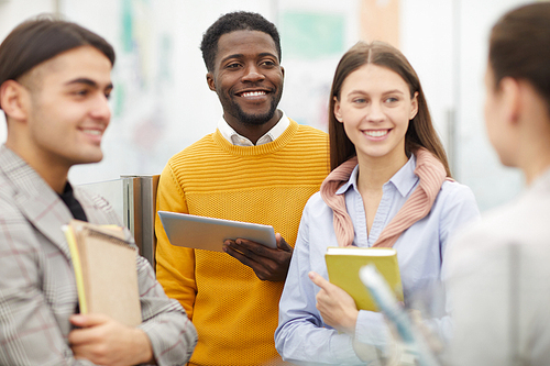 Group of cheerful students chatting during break in college