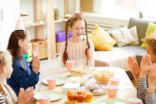 High angle portrait of happy red-haired girl celebrating birthday with friends at party table, copy space