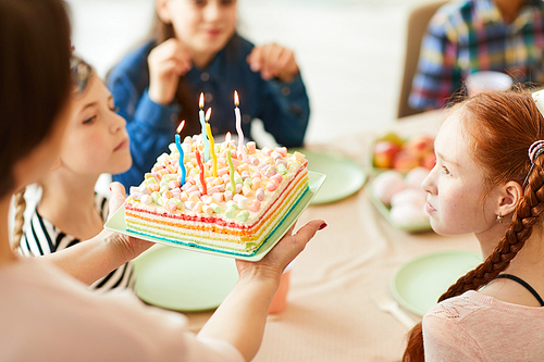 High angle closeup of mother bringing Birthday cake with candles for childrens party, copy space