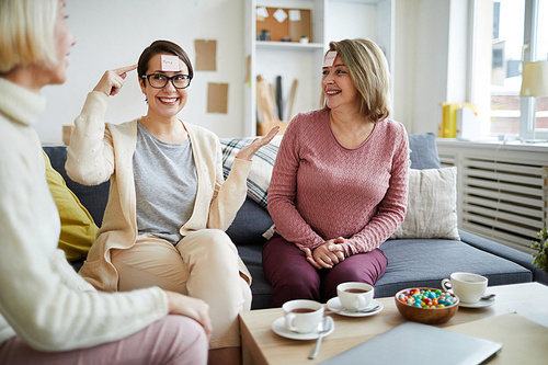 Portrait of three adult women playing games and having fun at home, copy space