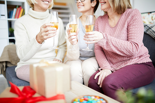Mid section portrait of three happy women clinking glasses and  while celebrating birthday at home, copy space