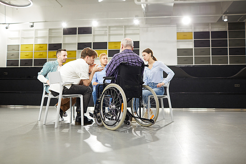 Back view portrait of handicapped man sharing troubles with support group during therapy session, copy space