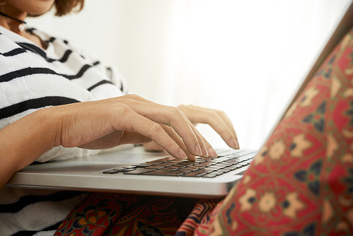 Hands of woman coding on laptop when working from home