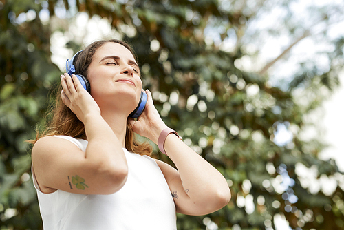 Attractive young smiling woman enjoying her favorite song