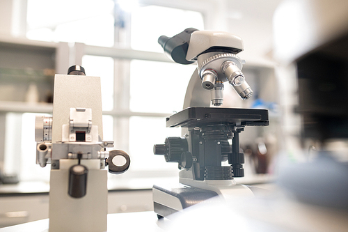 Close-up of optical instruments with magnifying lens used for researches placed on table in modern laboratory