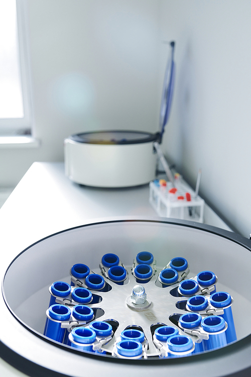 Close-up of opened laboratory centrifuge with samples inside of rotating units used for separating liquids