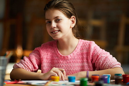 Portrait of smiling teenage girl  while drawing pictures in art class, copy space