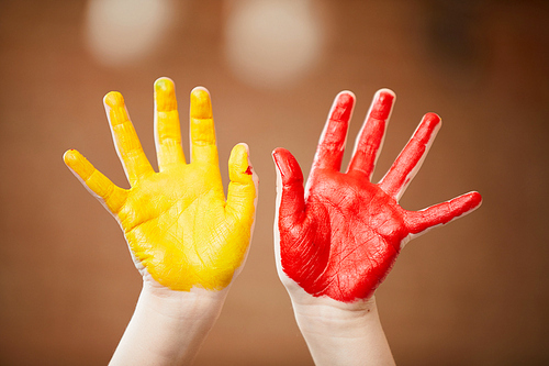 Close up of unrecognizable child showing hands colored with paint, finger painting and creativity concept , copy space