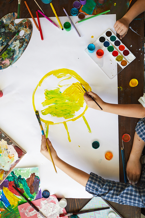 Top view background of two children drawing sun while painting picture together, copy space