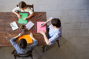 Above view portrait of children painting pictures at table with mom, copy space