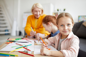 Portrait of cute little girl  while drawing pictures at home with family, copy space