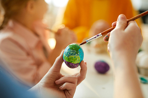 Closeup of unrecognizable girl holding egg and decorating for Easter, copy space