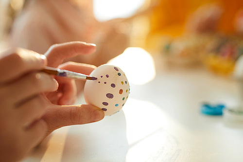 Close up of unrecognizable child painting eggs for Easter, copy space