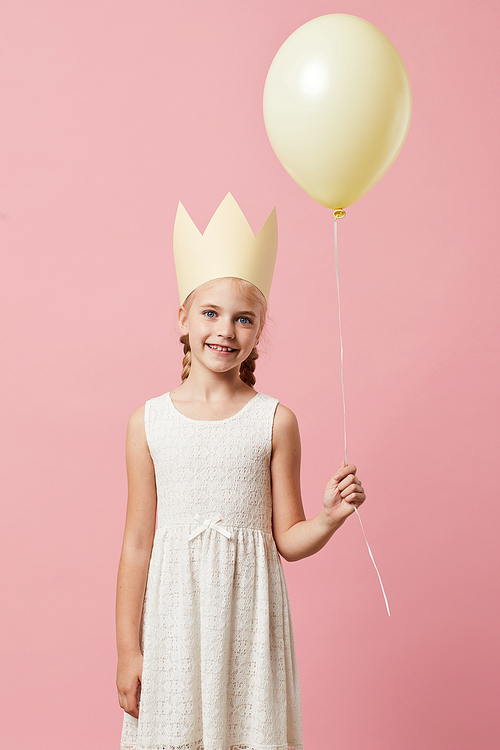 Waist up portrait of cute girl wearing crown posing against pink background, Birthday party concept
