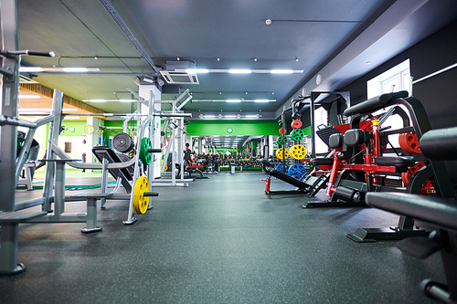 Sport club or gym interior with different simulators for weightlifting or bodybuilding