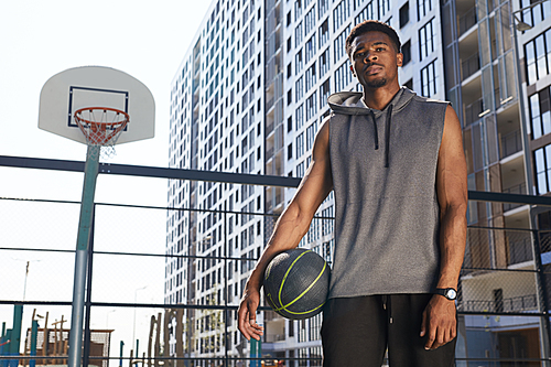 Portrait of African-American basketball player standing  in outdoor court, copy space
