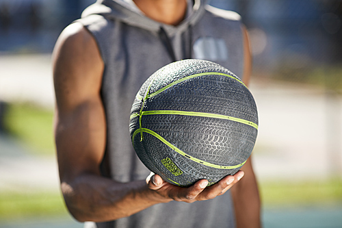 Closeup of African-American sportsman holding basketball ball, copy space