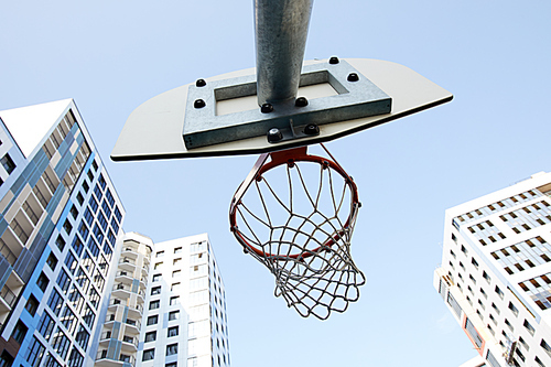 Low angle view of basketball hoop in urban background, copy space