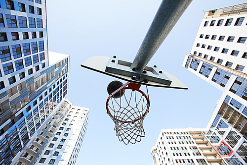 Low angle view at basketball hoop in urban background, copy space
