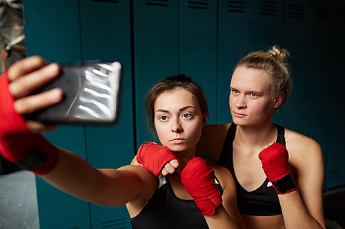 Portrait of two female fighters taking selfie in changing room before boxing practice, copy space