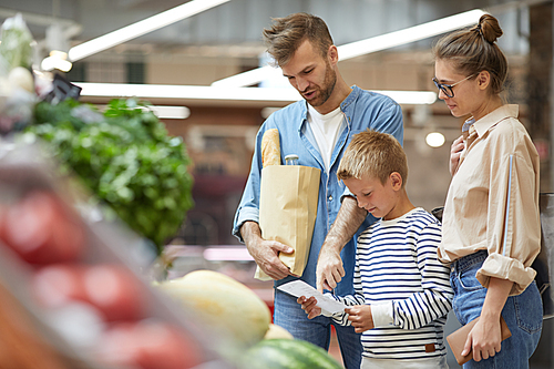 Waist up portrait of contemporary family shopping for groceries at farmers market, copy space