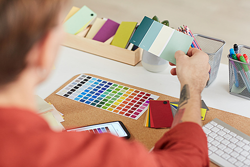 Close up of male designer choosing color palette while planning creative project at workplace in studio, copy space
