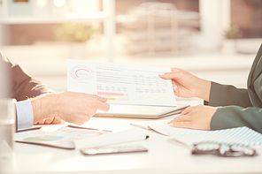 Close up of unrecognizable businessmen handing documents during business meeting in office, copy space