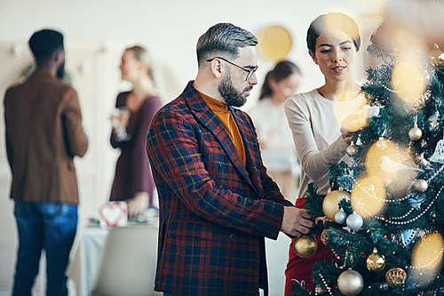 Side view portrait of modern adult man looking at Christmas decorations during banquet party, copy space
