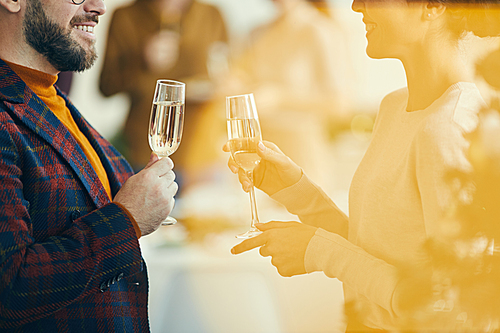 side view closeup of adult couple  champagne and talking during christmas party, golden flare overlay