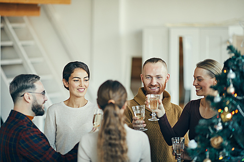 High angle view at group of elegant people clinking glasses during Christmas party at home, copy space