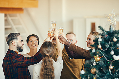 High angle view at group of elegant people clinking champagne glasses during Christmas party, copy space
