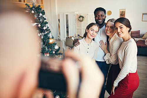 Multi-ethnic group of elegant adult people posing for photograph during Christmas party, copy space